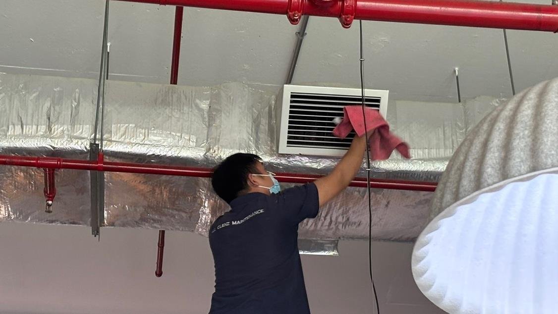 ACM crew member performing professional cleaning in a commercial building