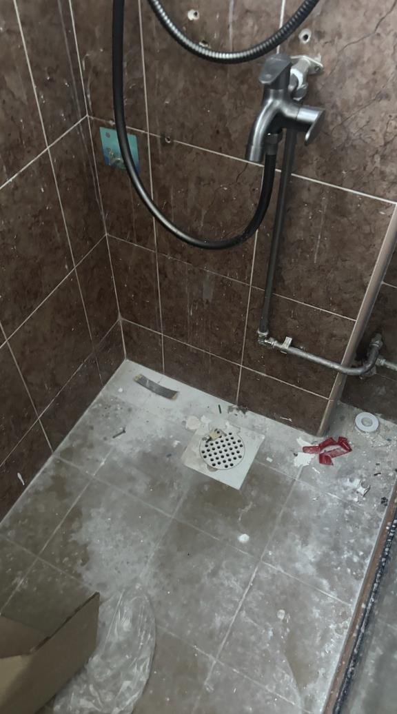 Bathroom covered in construction dust and debris before post-renovation cleaning