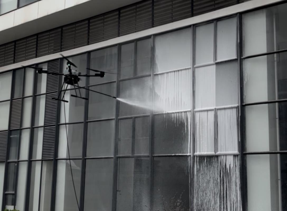 Drone performing external facade cleaning on a high-rise building